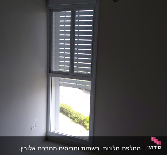 חלון אלומיניום עם תריסים בחדר ריק